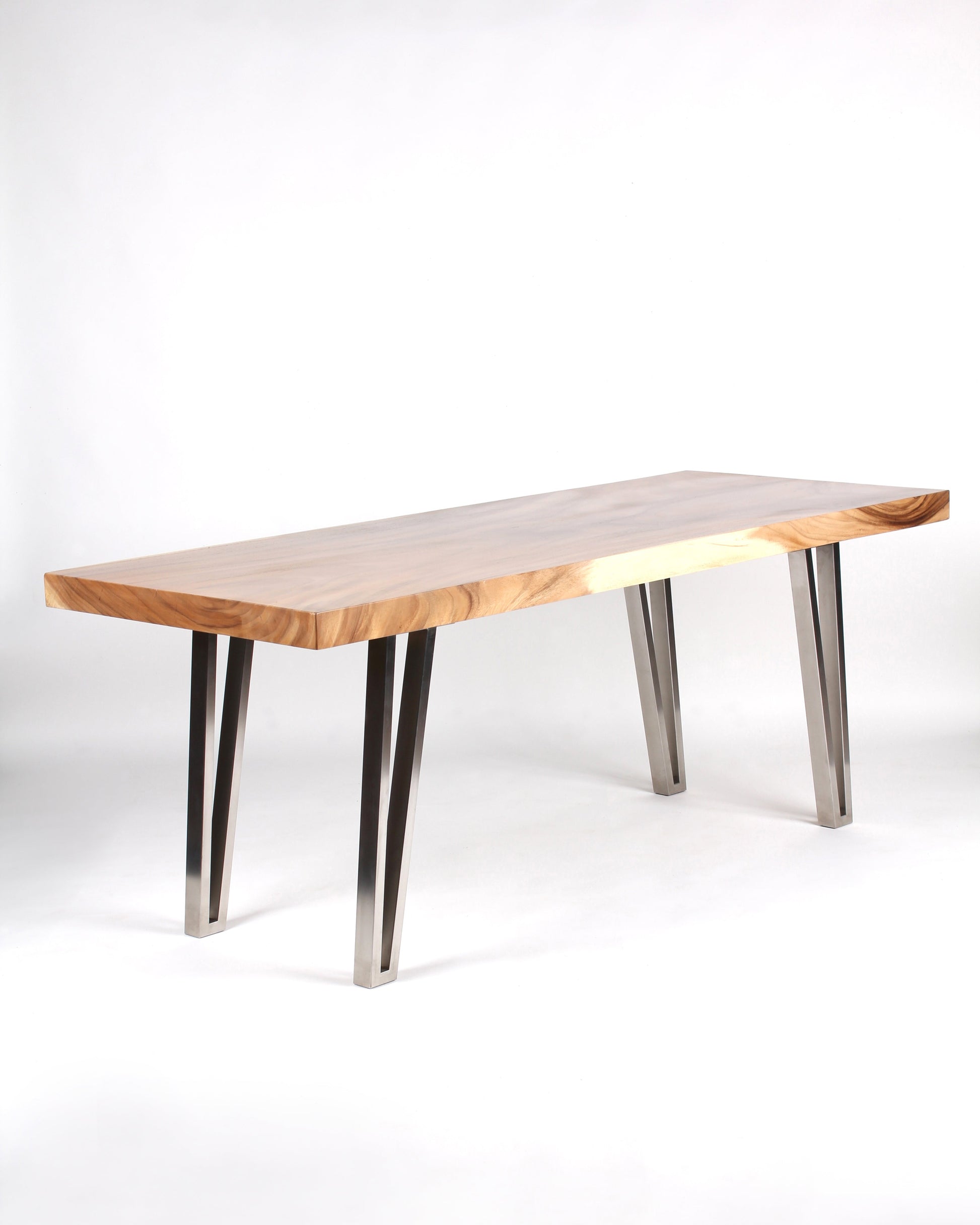 A rectangular dining table with a wooden top and stainless steel legs, positioned on a white background. The table appears to have a modern design with a significant discrepancy in material and style.